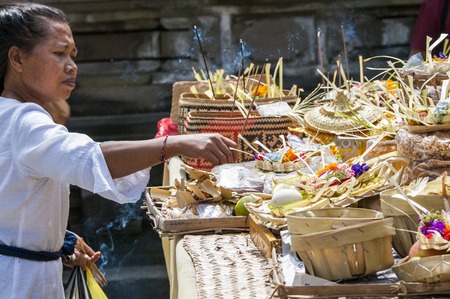 Bali, Indonesia - July 30, 2013. A few unidentified women preparing offerings and the ceremony in the hinduist buddhist Odalan temple.のeditorial素材