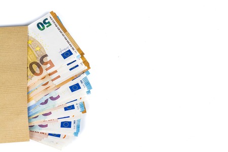 Brown envelope full of euro banknotes bills onwhite background. Concept of corruption and briberyの写真素材