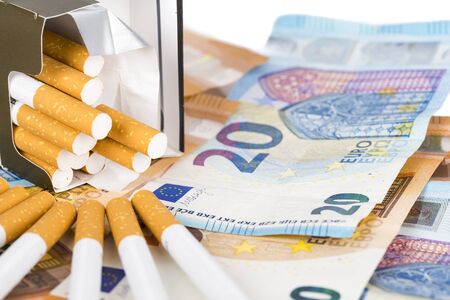 20 and 50 Euro banknotes bills cash with cigarettes, with cigarettes box. Concept of cost of tabacco, cigarettes. Front and top view, close-up.の写真素材