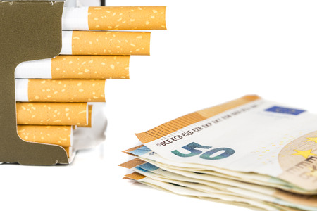 20 and 50 Euro banknotes bills cash with cigarettes, increase graph made with cigarettes. Concept of cost of tabacco, cigarettes. Front and top view, close-up.の写真素材