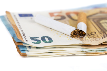 Cigarette broken on euro banknotes. Concept of waste of health and money lost due to smoking addiction - Stopping smokingの写真素材