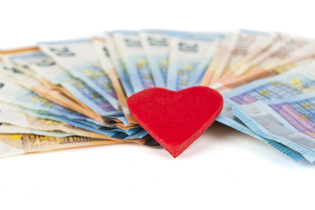 Red heart on euro banknotes bills. On white background. love and moneyの写真素材