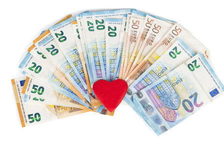 Red heart on euro banknotes bills. On white background. love and moneyの写真素材