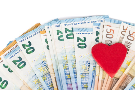 Red heart on euro banknotes bills. On white background. love and moneyの写真素材