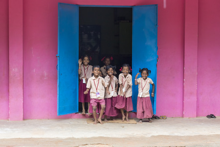 PONDICHERY, PUDUCHERY, INDIA - SEPTEMBER 04, 2017. Pink and blue school with happy chidren with uniforms near the doorのeditorial素材