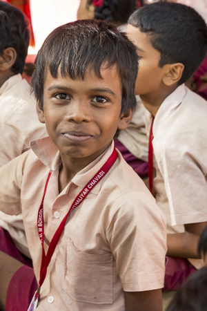 PONDICHERY, PUDUCHERY, INDIA - SEPTEMBER 04, 2017. Outdoor meeting of the children of the school, with uniforms, sitting on the floor, waiting for sport equipments as a gift from an association.のeditorial素材