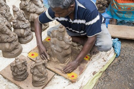 Close up of hand crafted Ganesha idol clay statues displayed in the market during Ganesh Festival.のeditorial素材