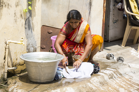 PUDUCHERY, PONDICHERY, TAMIL NADU, INDIA - March circa, 2018. Unidentified indian woman wash laundry clothes outdoors. Indiaのeditorial素材