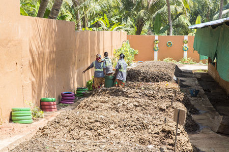Unidentified people looking at the compost storage. Compost soil, Organic plant fertilizer made with fruits vegetable oranic waste, for plantation. Environement recyclingのeditorial素材