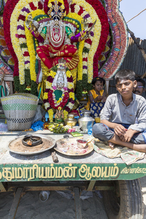 Unidentified brahman man with statues of the Indian gods and offerings., to give to people.