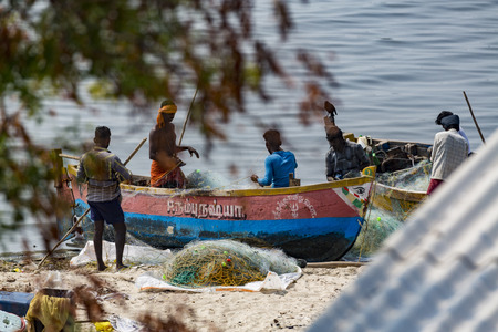 Documentary editorial. RAMESWARAM, RAMESHWARAM, PAMBAN ISLAND, TAMIL NADU, INDIA - March circa, 2018. Unidentified poor local Traditional fisherman are fishing on the beach with very small colored wood boats. Asiaのeditorial素材