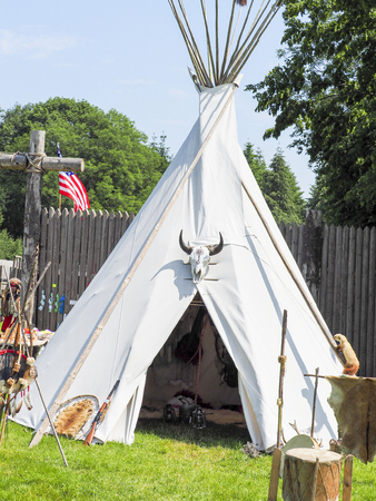 A single, solitary teepee in a field. Teepees are used in many summer camps as shelter for the...