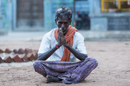 PUDUCHERY, PONDICHERRY, TAMI NADU, INDIA - SEPTEMBER CIRCA, 2017. An unidentified man sits with crossed legs and hands meditating in front of an hinduist templeのeditorial素材
