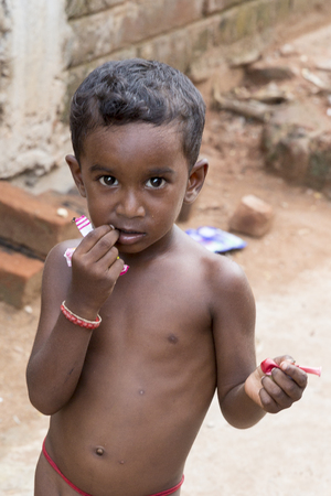 PONDICHERY, PUDUCHERRY, TAMIL NADU, INDIA - SEPTEMBER CIRCA, 2017. Portrait of an unidentified poor indian boy eating his snack in the street. Vlose-upのeditorial素材