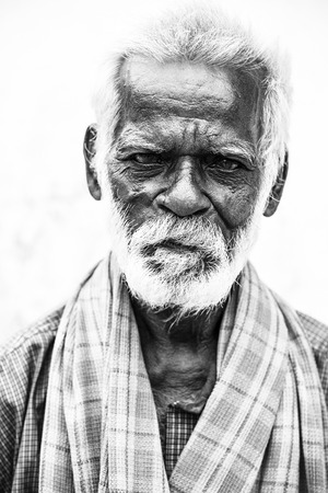 PONDICHERY, PUDUCHERRY, TAMIL NADU, INDIA - SEPTEMBER CIRCA, 2017. An unidentifed old senior indian poor man portrait with a dark brown wrinkled face and white hair and a white beard, looks serious or sad. Black and whiteのeditorial素材