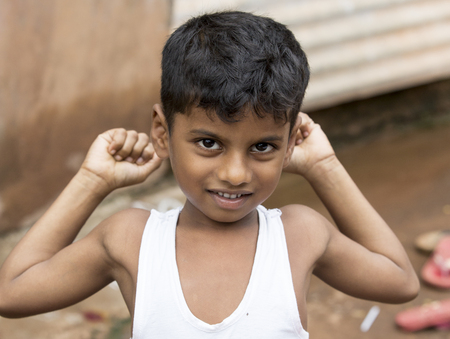 PONDICHERY, PUDUCHERRY, TAMIL NADU, INDIA - SEPTEMBER circa, 2018. An unidentified poor indian boy with a smiling and serious eyes looks in the cameraのeditorial素材