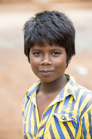 PONDICHERY, PUDUCHERRY, TAMIL NADU, INDIA - SEPTEMBER circa, 2018. An unidentified poor indian boy with a smiling and serious eyes looks in the cameraのeditorial素材