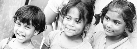 PONDICHERY, PUDUCHERRY, TAMIL NADU, INDIA - SEPTEMBER CIRCA, 2017. Portrait of 3 unidentified Indian poor kid child girl is smiling outdoor in the street/ Black and whiteのeditorial素材
