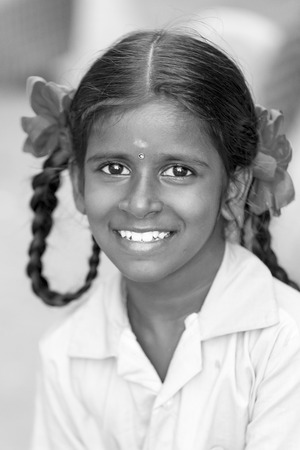 PONDICHERY, PUDUCHERRY, TAMIL NADU, INDIA - SEPTEMBER CIRCA, 2017. Portrait of unidentified Indian poor kid child girl is smiling outdoor in the street/ Black and whiteのeditorial素材