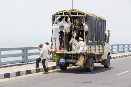 Unidentified indian men crowd into the back of a truck to be transported to work in the fieldsのeditorial素材
