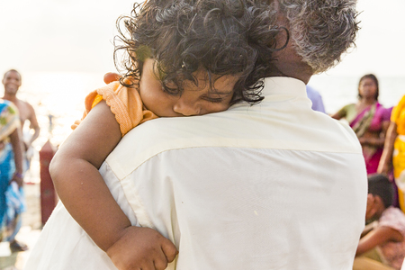 RAMESHWARAM, TAMIL NADU, INDIA - MARCH CIRCA, 2018. Smiling indian child in the arms of his father.のeditorial素材
