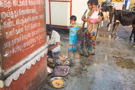 RAMESHWARAM, TAMIL NADU, INDIA- MARCH CIRCA, 2018. Unidentified indian pilgrim performing rituals Puja, with families, just before going to the temple.のeditorial素材