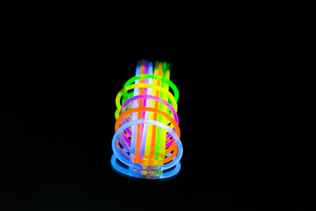 Colorful fluorescent light neon glow stick on black background.