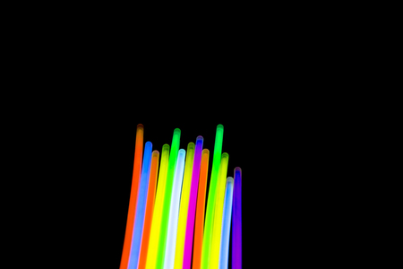 Colorful fluorescent light neon glow stick on black background.の写真素材