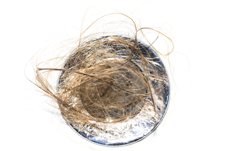 Hair loss on washbasin. Long wet brown hair on white basin in the bathroom. Healthcare conceptの写真素材