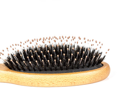 Wood hairbrush on white background. Close-up without hair. Hair Loss problem