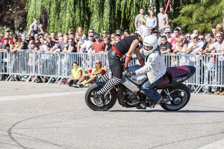 LE TRAIT, SEINE MARITIME, NORMANDY, FRANCE - SEPEMBER 01, 2018. Moto-show in central square of city. Tricks on ATV stuntmen, Stunt Riding - Wheelie, Stoppie and extreme acrobatics somersault on motorbike with a woman. Outdoor spectacleのeditorial素材