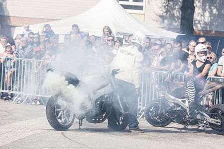 LE TRAIT, SEINE MARITIME, NORMANDY, FRANCE - SEPTEMBER 01, 2018. Moto-show in central square of city. Tricks on ATV stuntmen, Stunt Riding - Wheelie, slides, sliding, Stoppie and extreme acrobatics somersault on motorbikeのeditorial素材