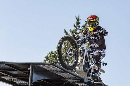 LE TRAIT, SEINE MARITIME, NORMANDY, FRANCE - SEPTEMBER 01, 2018. Moto-show in central square of city. Tricks on ATV stuntmen, Stunt Riding - Wheelie, Stoppie, jump in the air and extreme acrobatics somersault on motorbike with platform. Outdoor spectacleのeditorial素材