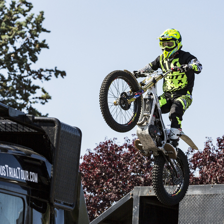 LE TRAIT, SEINE MARITIME, NORMANDY, FRANCE - SEPTEMBER 01, 2018. Moto-show in central square of city. Tricks on ATV stuntmen, Stunt Riding - Wheelie, Stoppie, jump in the air and extreme acrobatics somersault on motorbike with platform. Outdoor spectacleのeditorial素材