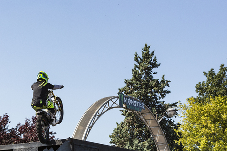 LE TRAIT, SEINE MARITIME, NORMANDY, FRANCE - SEPTEMBER 01, 2018. Moto-show in central square of city. Tricks on ATV stuntmen, Stunt Riding - Wheelie, Stoppie, jump in the air and extreme acrobatics somersault on motorbike with platform. Outdoor spectacleのeditorial素材