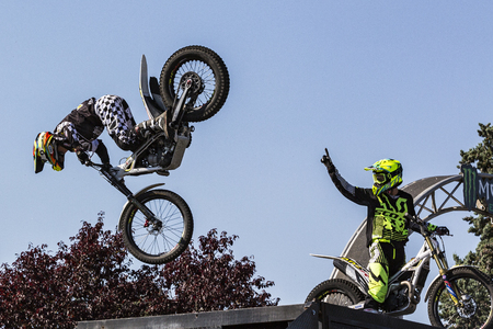LE TRAIT, SEINE MARITIME, NORMANDY, FRANCE - SEPTEMBER 01, 2018. Moto-show in central square of city. Tricks on ATV stuntmen, Stunt Riding - Wheelie, Stoppie, jump in the air and extreme acrobatics somersault on motorbike with platform. Outdoor spectacleのeditorial素材