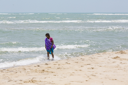 Documentary editorial. DANUSHKODI, PAMBAN ISLAND, TAMIL NADU, INDIA - March circa, 2018. Unidentified young women girl couple taking a walk at beautiful sunny morning at Danushkodi beachのeditorial素材
