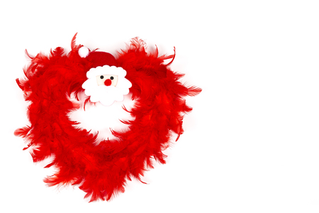 Red Heart Christmas Decoration made with red feather, with Santa Claus head in the middle, on white backgroundの写真素材