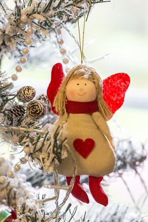 Close up shot of a christmas tree with beautiful decoration. Colorful angel hanging on a christmas tree. with snowの写真素材