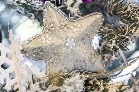 Close up shot of a christmas tree with beautiful decoration. silver star decoration hanging on a...