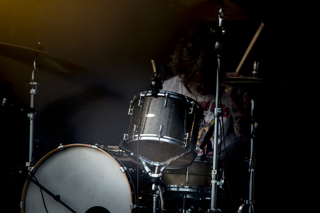 Man drum instrument performing at stage rock music. Scene outdoor light. Authentic shooting with high iso in challenging lighting conditions.の写真素材