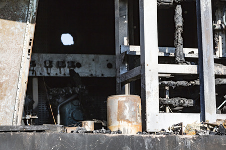 Damaged supermarket boiler room with ventilation, turbine, after arson fire with burn black dark debris intense burning fire disaster ruins waiting for investigation for insurance. Saturated contrasting effect dramatic atmosphereの写真素材