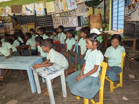 PUDUCHERRY, INDIA - DECEMBER Circa, 2018. Unidentified happy pupils classmates in government school uniforms sitting, studying indoors classroom. Portrait of school poor teenagers smiling for ngo help.のeditorial素材