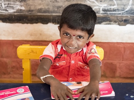 PUDUCHERY, INDIA - DECEMBER Circa, 2018. Unidentified cute beautiful poor smiling kid reading a book...