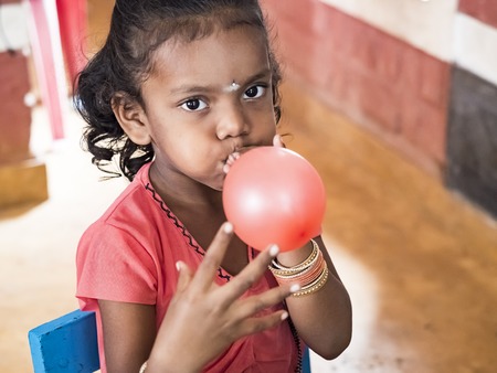 PUDUCHERY, INDIA - DECEMBER Circa, 2018. Unidentified cute beautiful poor smiling kidindlatting...