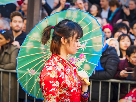 PARIS, FRANCE - FEBRUARY 17, 2019. Last day of the chinese new year celebration festival in street. Portrait of woman show with colorful costumes and decorations. Happy face and concentration. Year of pigのeditorial素材