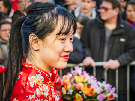PARIS, FRANCE - FEBRUARY 17, 2019. Last day of the chinese new year celebration festival in street. Portrait of woman show with colorful costumes and decorations. Happy face and concentration. Year of pigのeditorial素材