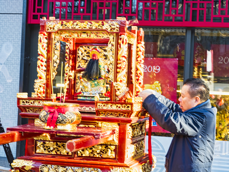 PARIS, FRANCE - FEBRUARY 17, 2019. Last day of the chinese new year celebration festival in street. Buddha statue outdoor with incence burning for people praying and wishing a happy new year. Traditional customのeditorial素材