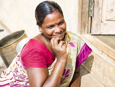 PUDUCHERY, INDIA - DECEMBER Circa, 2018. Unidentified portrait of a happy smiling mature indian woman with hand on chin looking at camera. Close up face of beautiful asian woman with brown hair in street villageのeditorial素材