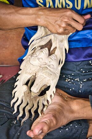 BALI, INDONESIA - FEBRUARY Circa, 2019. Unidentified Indonesian man carpenter cabinet worker working with a chisel in his workshop, sitting on the floor. Very accurate manual work.のeditorial素材